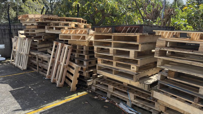 Used pallets stacked in a carpark before collection